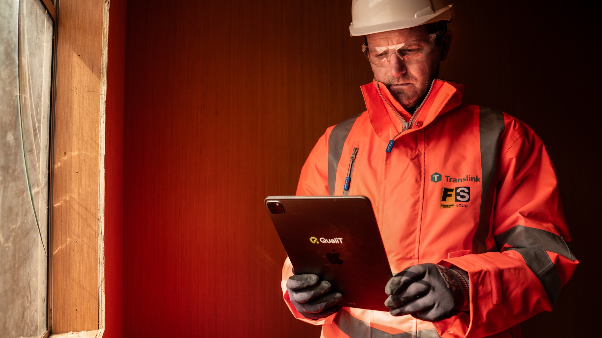 A site operative using the QualiT app on a tablet on site
